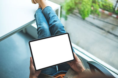 Midsection of woman using digital tablet
