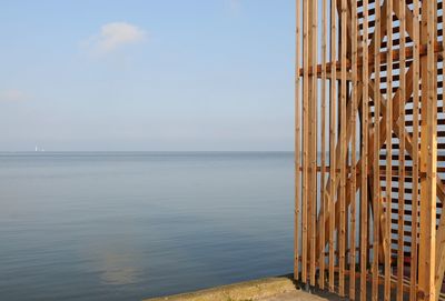 Wooden structure on pier by sea against sky