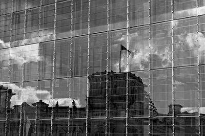 Full frame shot of modern glass building in city, reflection of reichstag