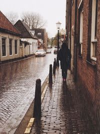 Rear view of person walking in the rain