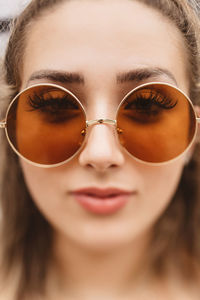 Close-up portrait of young woman wearing sunglasses