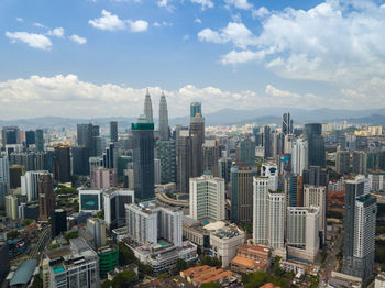 Petronas towers amidst cityscape against sky