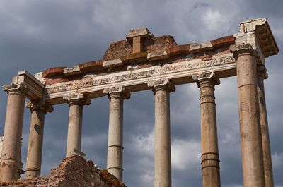 Low angle view of ancient roman forum against cloudy sky