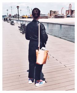 Rear view of woman with umbrella walking in city