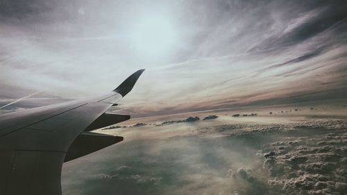 Close-up of airplane wing over sea against sky