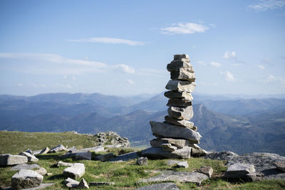 Stack of rocks on mountain against sky