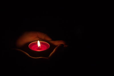 Close-up of burning candle in darkroom