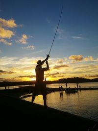 Silhouette of people in sea at sunset