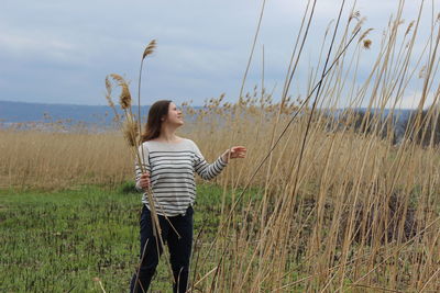 Full length of woman standing on field against sky