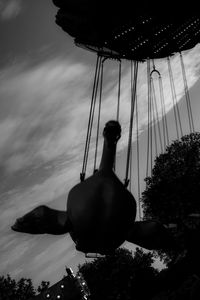 Low angle view of swing ride against sky