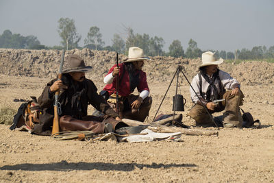 Men sitting in park against sky