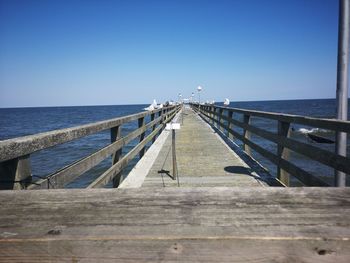 Pier over sea against clear sky