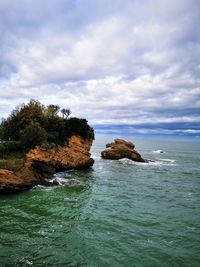 Rocks in sea against sky