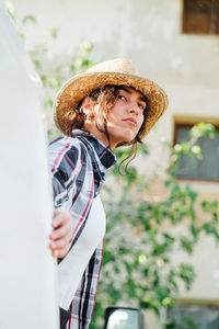 Woman wearing hat standing in van