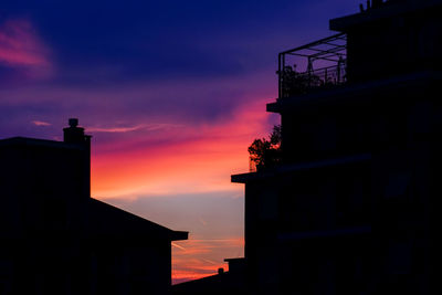 Low angle view of silhouette buildings against sky during sunset