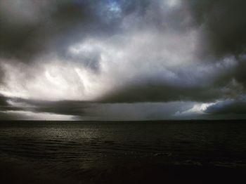 Scenic view of sea against storm clouds