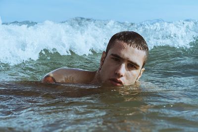 Portrait of young man swimming in sea