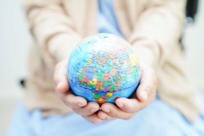 Midsection of woman holding crystal ball