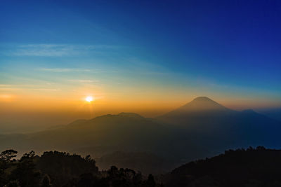 Scenic view of silhouette mountains against sky during sunset