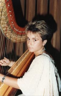 Side view portrait of woman playing harp by wall