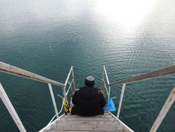 Rear view of man fishing in sea