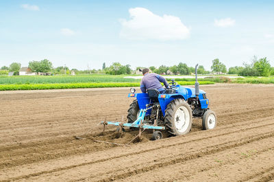 Farmer on a tractor with a cultivator processes a farm field. soil preparation