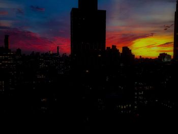 Skyscrapers in city at sunset