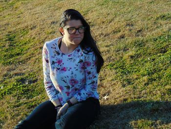 Portrait of young woman sitting on grass