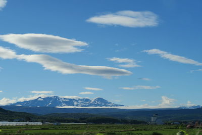 Scenic view of field and mountains against sky