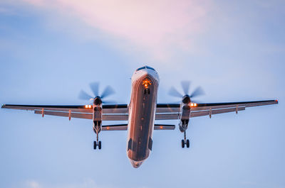 Low angle view of airplane against sky at dusk