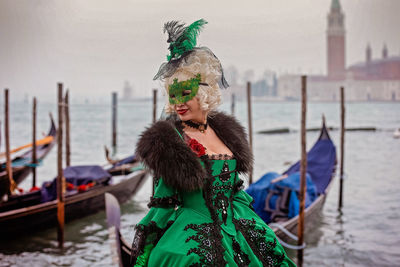 Woman standing by boat in canal