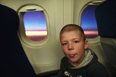 Boy sitting by window in airplane