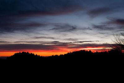 Scenic view of silhouette landscape against dramatic sky during sunset