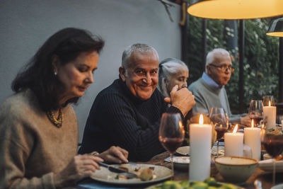 Portrait of smiling mature man with senior friends during dinner party