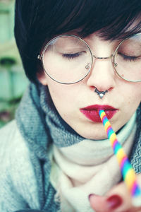 Close-up of mid adult woman holding straw in mouth