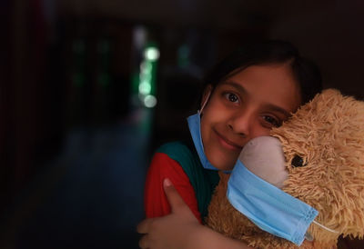 Indian girl hugging tedy bear during corona virus pendemic, at home