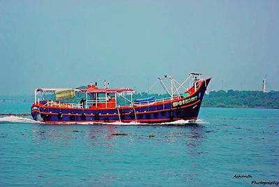 Boat on sea against clear blue sky