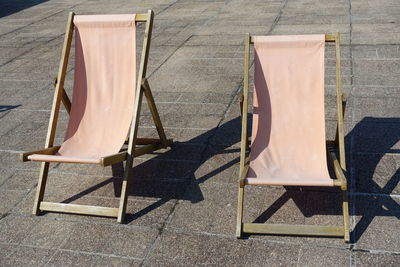 High angle view of chairs on concrete on sunny day