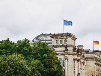 Low angle view of flag on building against sky