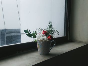 Flower vase on window sill at home