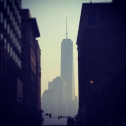 Skyscrapers in city against cloudy sky