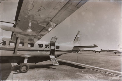 Airplane on airport runway against sky