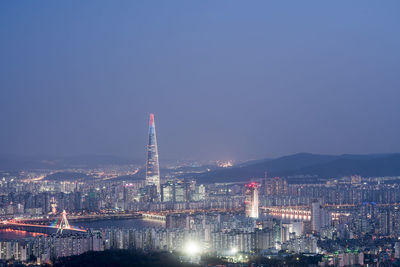 Illuminated cityscape against sky at night