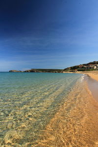 Scenic view of beach against blue sky