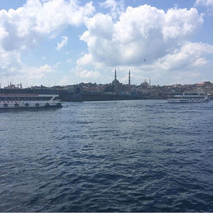 Sailboats in sea against buildings in city