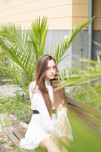 Young woman looking away while sitting outdoors