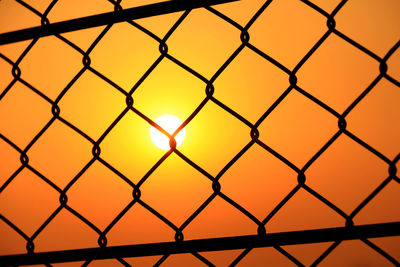 Close-up of chainlink fence during sunset