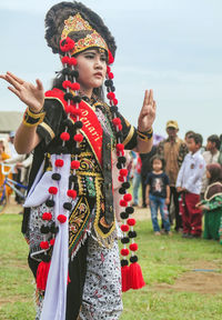 Friends wearing traditional clothing against sky