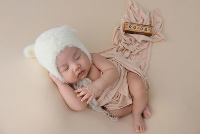 High angle view of cute baby girl sitting on bed