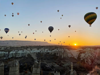 Hot air balloons flying in sky at sunset